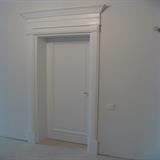 Białe drzwi drewniane z gzymsem ozdobnym